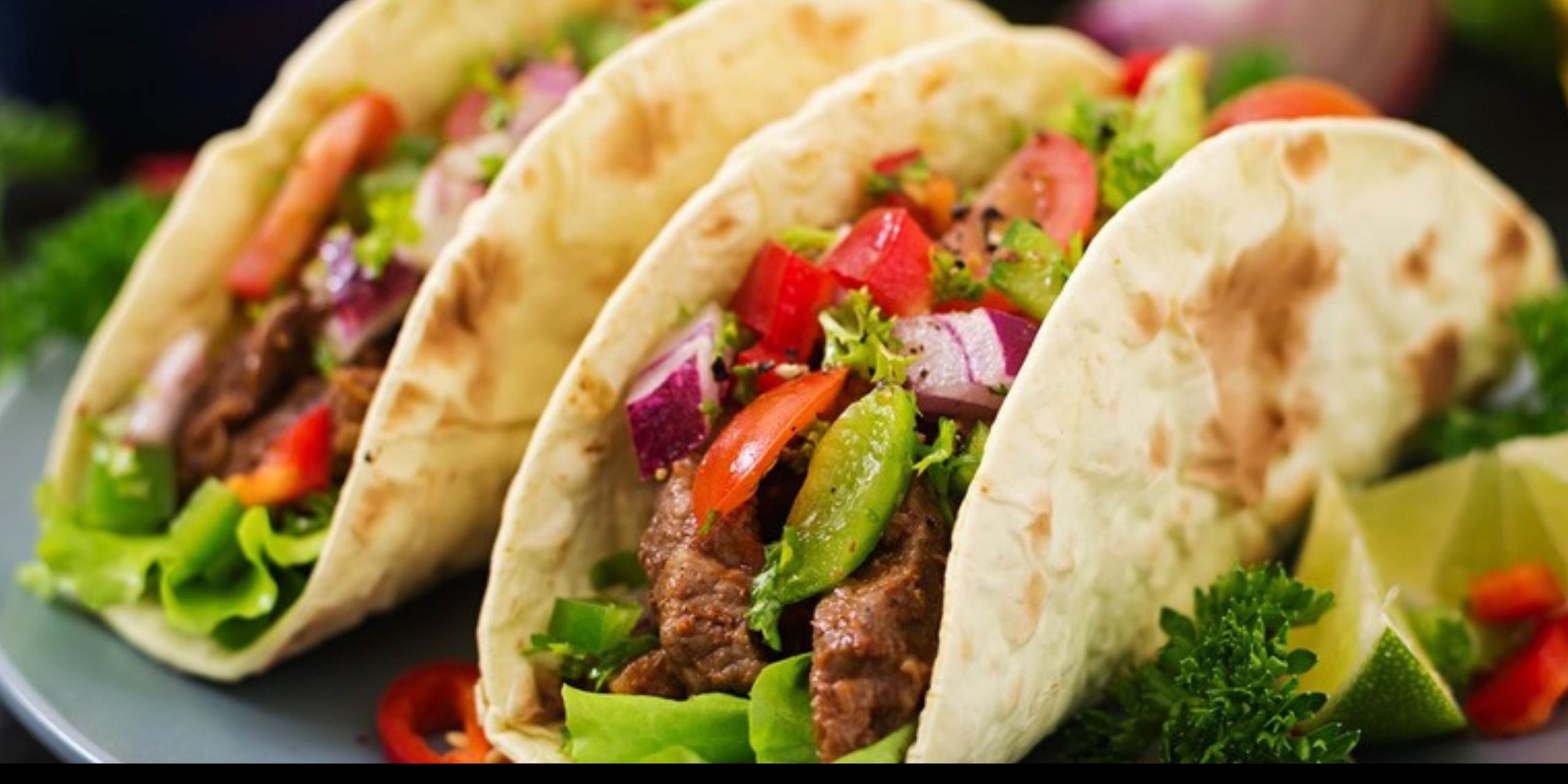 Street tacos with seasoned steak, peppers, onion, and fresh herbs
